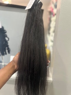 Hair extensions held by a person with a blurred background